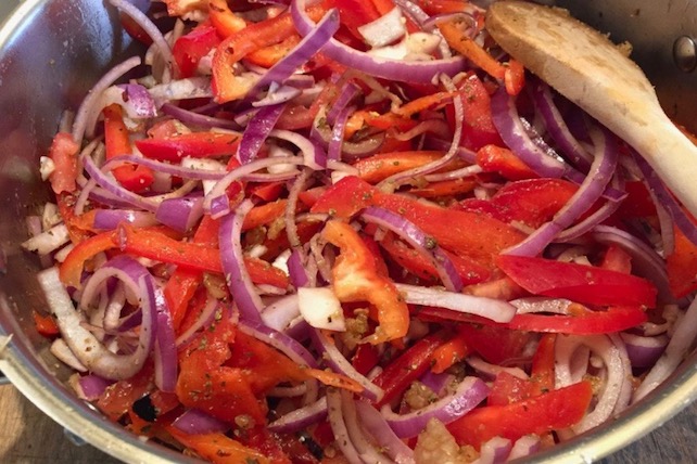 sliced onions and peppers seasoned for a sausage skillet dinner