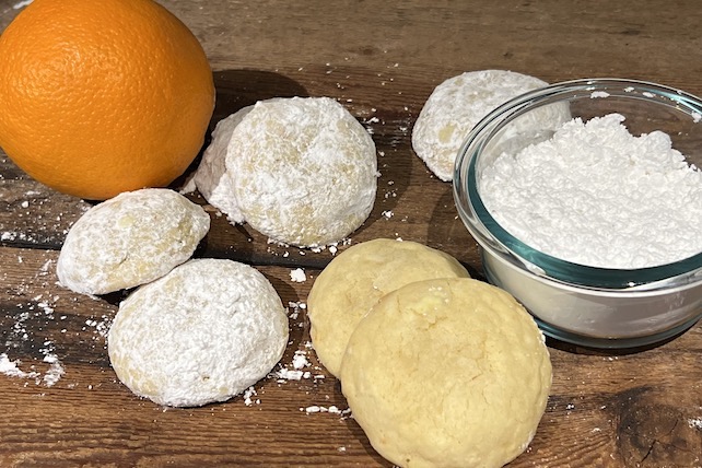 orange sugar cookies covered in powdered sugar